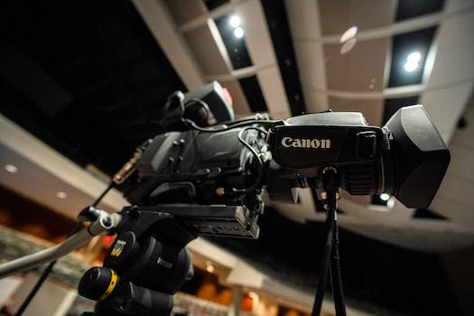 Modern digital movie camera placed in recording video studio