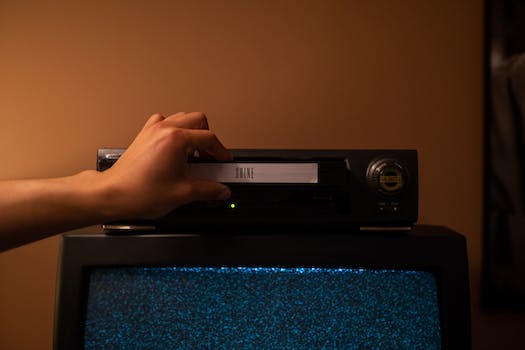 Person inserting a videotape into the video player