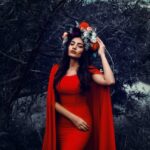 Young Brunette in a Red Dress and a Flower Crown Posing Outdoors