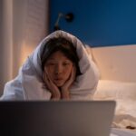 Portrait of Woman With Hands on Chin Watching Movie on Laptop