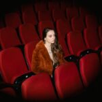 Woman in Brown Fur Coat Sitting on Red Chair