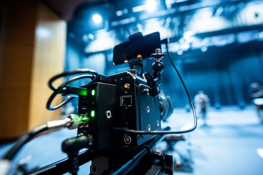 Professional black video camera with wires located in professional recording studio during process of filming